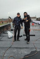 zwei talentierte Dachdecker haben gemeinsam Spaß auf einem Flachdach