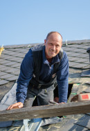 Ein Dachdecker arbeitet an einem schönen Naturschieferdach in Koblenz
